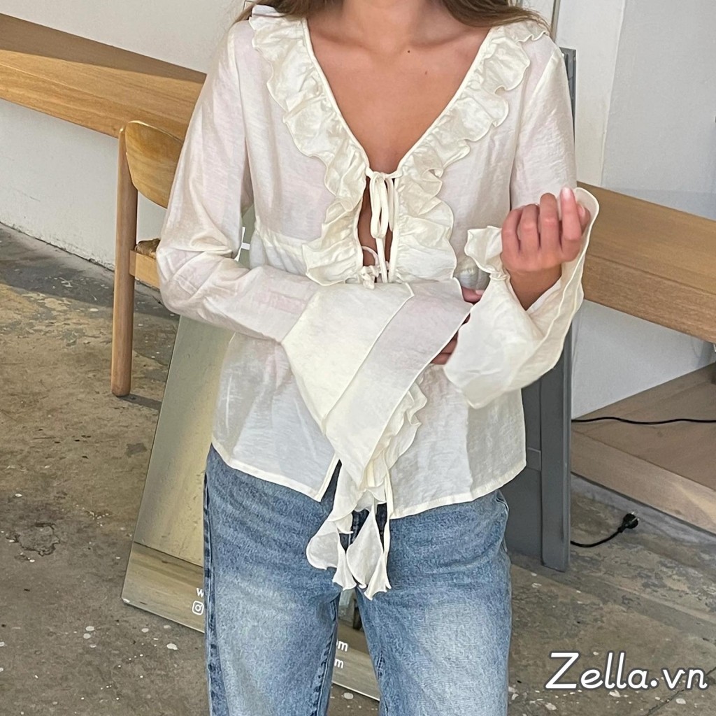 Áo sơ mi nữ thiết kế dáng rộng phía trước có nơ, tay dài, cổ chữ V và phần eo xòe ra (peplum)