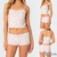Trang phục nữ bộ đôi: ren chắp vá, gồm áo hai dâycrop cổ chữ V in nơ và quầnshort co giãn