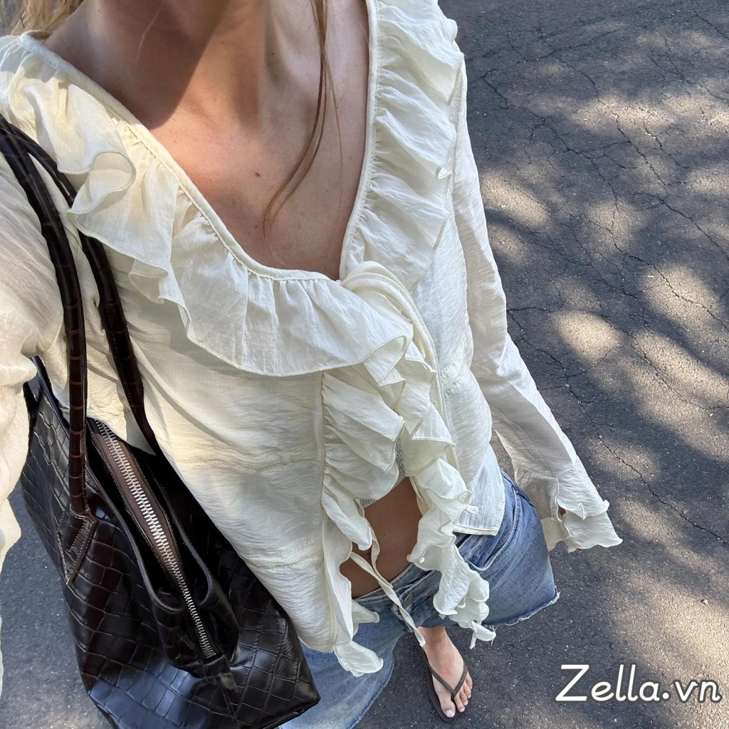 Áo sơ mi nữ thiết kế dáng rộng phía trước có nơ, tay dài, cổ chữ V và phần eo xòe ra (peplum)