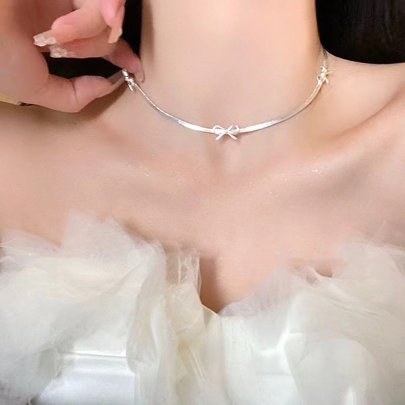Vòng cổ nơ bạc tinh tế, phù hợp cho phụ kiện thời trang sang trọng.