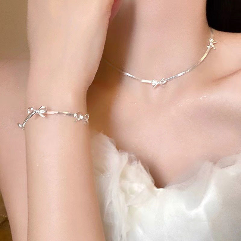 Vòng cổ nơ bạc tinh tế, phù hợp cho phụ kiện thời trang sang trọng.