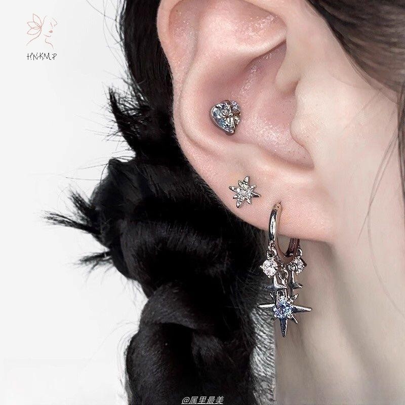 Bộ trang sức nữ gồm bông tai và mặt dây chuyền hình ngôi sao tám cánh, màu bạc với đá blue zircon, phù hợp làm quà tặng.