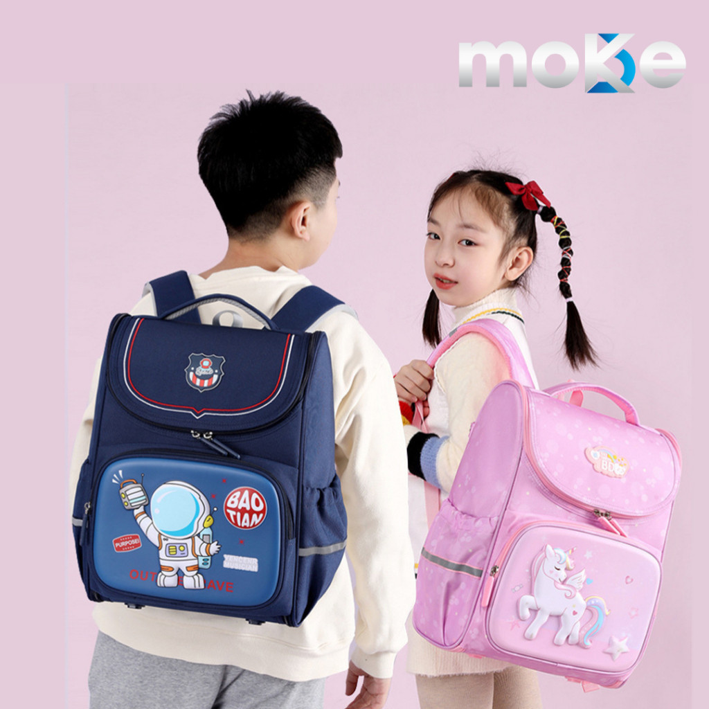 Bé gái lớp 1 rạng rỡ khoác chiếc ba lô form hộp màu hồng pastel, bên cạnh là bé trai tạo dáng năng động với ba lô siêu anh hùng