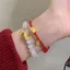 Vòng tay bện từ dây đỏ và bánh bao vàng, thiết kế mắt mèo độc đáo
