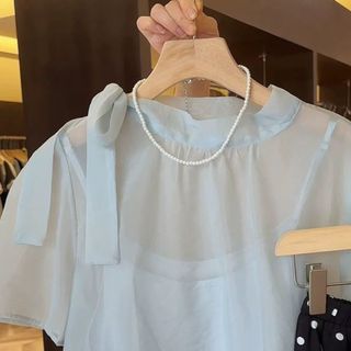 Áo sơ mi và áo yếm dáng rộng, thiết kế thắt nơ ngắn tay, chất liệu voan ruy băng trong suốt cùng màu trơn đơn giản
