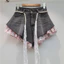 Quần short denim nữ retro với thiết kế khâu hoa hồng giả hai mảnh, phong cách thời thượng và ngọt ngào.