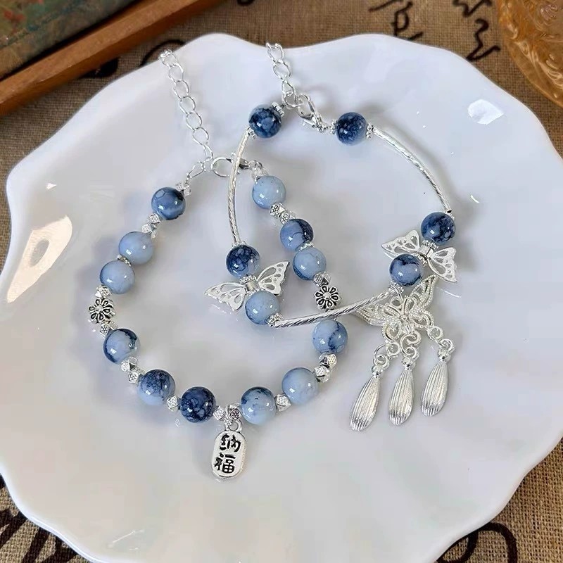 Vòng tay sứ xanh trắng phong cách cổ điển, có đính cườm và tua rua dạng cánh bướm, phù hợp đeo mỗi ngày