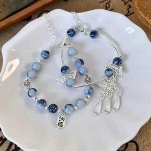 Vòng tay sứ xanh trắng phong cách cổ điển, có đính cườm và tua rua dạng cánh bướm, phù hợp đeo mỗi ngày