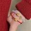 Vòng tay bện từ dây đỏ và bánh bao vàng, thiết kế mắt mèo độc đáo