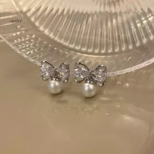 Bông tai màu vàng với ngọc trai và họa tiết hoa xoắn ốc, phù hợp phong cách thời trang cá tính và cổ điển.