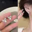 Bông tai màu vàng với ngọc trai và họa tiết hoa xoắn ốc, phù hợp phong cách thời trang cá tính và cổ điển.