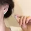 Bông tai màu vàng với ngọc trai và họa tiết hoa xoắn ốc, phù hợp phong cách thời trang cá tính và cổ điển.