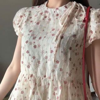 Áo Flower hoa nhí babydoll cổ tròn màu kem phối dây nơ điệu đà màu sắc nữ tính 2026 siêu hot