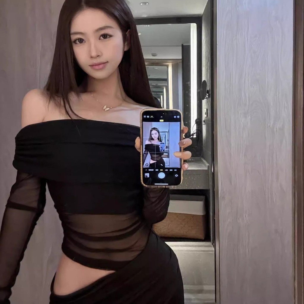 Áo lưới một vai dài tay phối cùng đầm lưới đen ôm dáng lộ eo, phong cách sang trọng