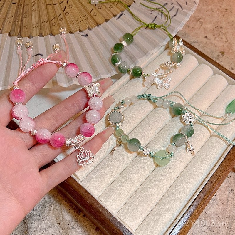 Vòng tay nữ thiết kế hoa sen và bướm màu hồng đính hạt, phù hợp với phụ kiện retro sang trọng