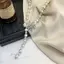 Hoa văn camellia và bông tuyết trên áo len nữ với phụ kiện ngọc trai sang trọng.