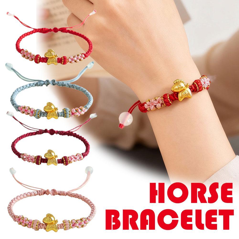 Vòng tay nữ phong cách dân tộc với thiết kế bện thủ công, nút dây đỏ và họa tiết hoa đào.