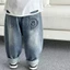 trẻ em quần denim mùa xuân phong cách mới bé trai và bé gái khuôn mặt tươi cười dáng rộng phong