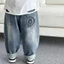 trẻ em quần denim mùa xuân phong cách mới bé trai và bé gái khuôn mặt tươi cười dáng rộng phong