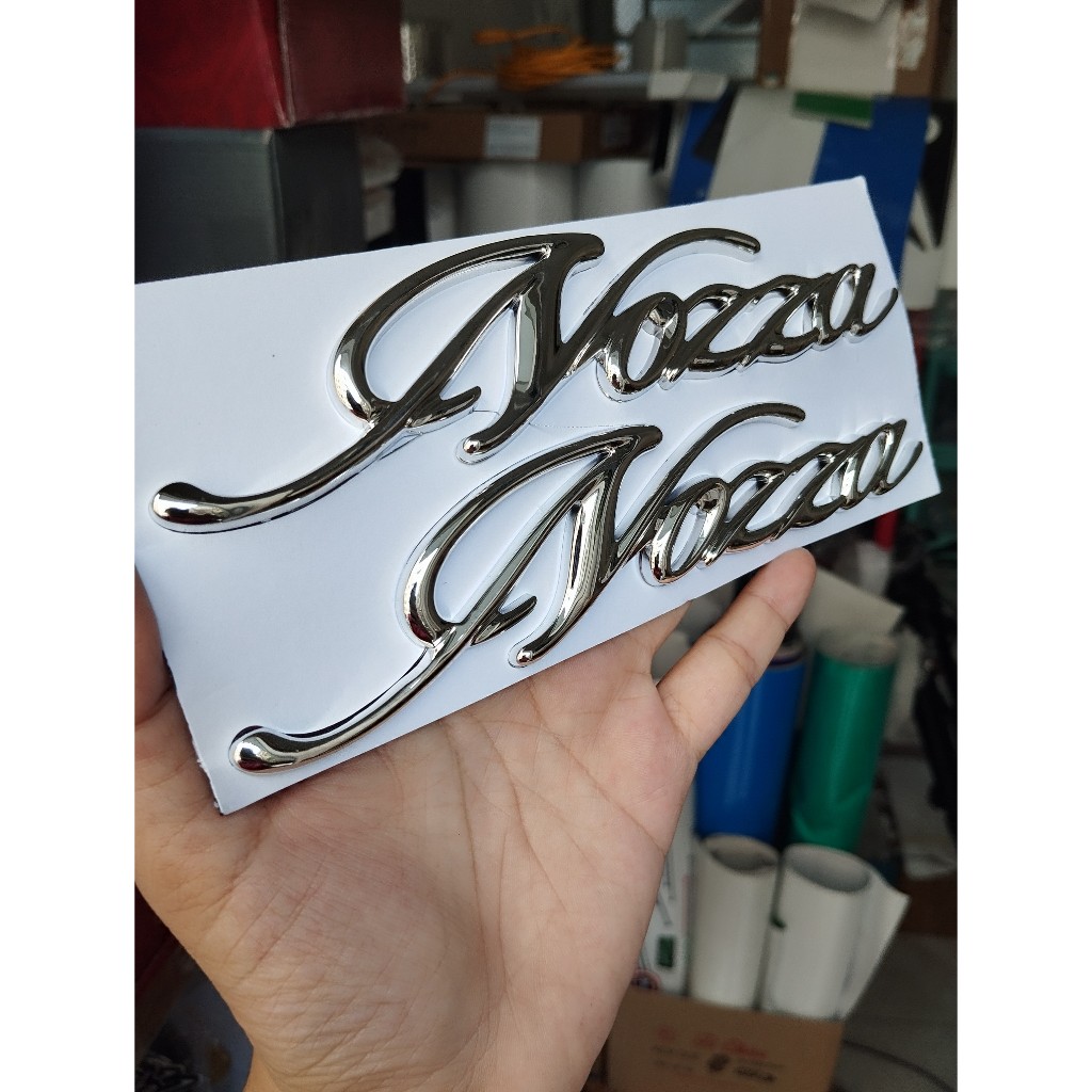 Tem Nozza chữ nổi ốp sườn. Logo dán xe Honda Nozza xi mạ cao cấp, có sẵn keo dán