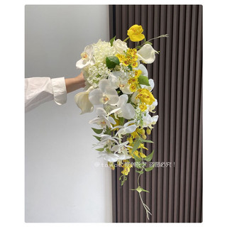 Hoa cưới cầm tay cô dâu ráng thức đồ màu trắng vàng