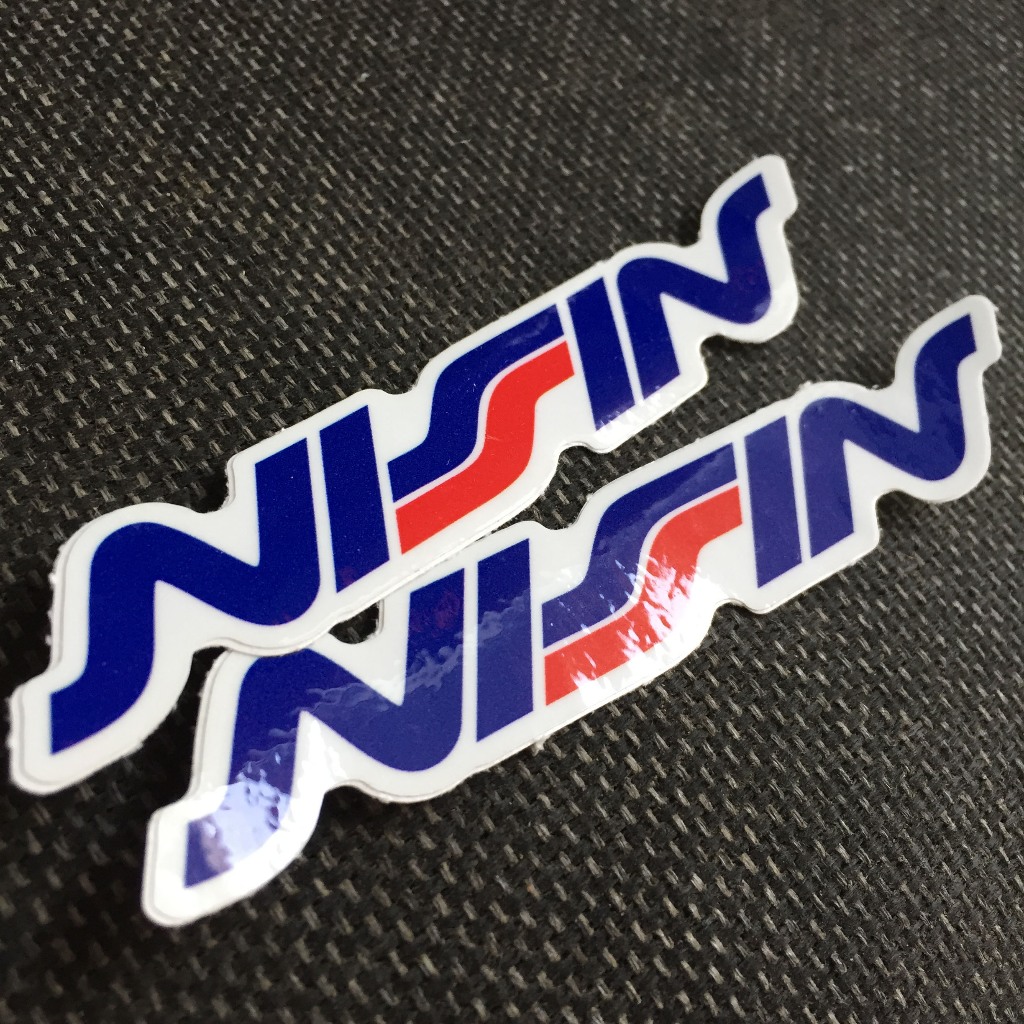 NISSIN[11.2x2cm] decal cao cấp chống nước, sắc nét, bền màu, dính chặt. Hình dán logo trang trí mọi nơi, in theo yêu cầu