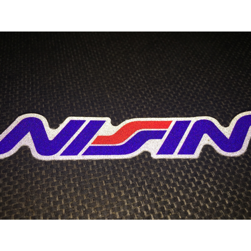 Logo NISSIN[11.2x2cm] decal phản quang 3M cao cấp chống nước. Hình dán sắc nét, bền màu, dính chặt.