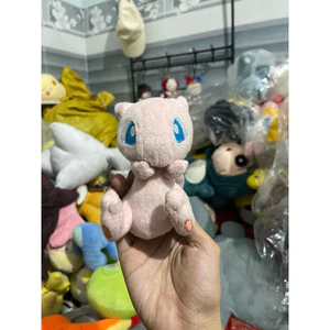 Gấu 2hand thú bông Pokémon Mew với đôi mắt màu xanh dương đặc trưng và đôi bàn chân nhỏ màu hồng.