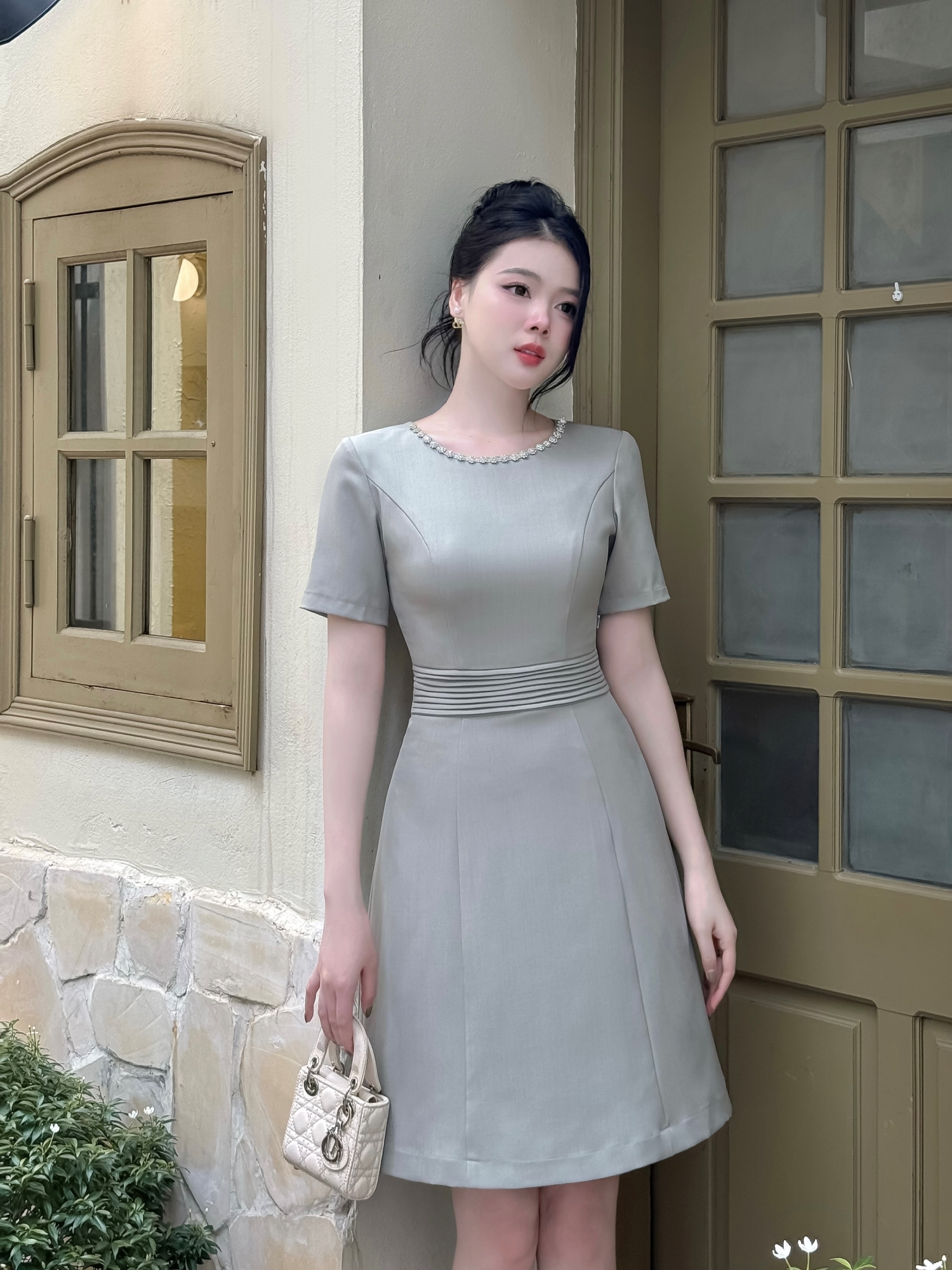 Mô tả Váy nữ dáng A xếp ly eo cổ viền đính đá trang trí ngắn tay vải text ô liu màu xanh YAME AV43 - 1