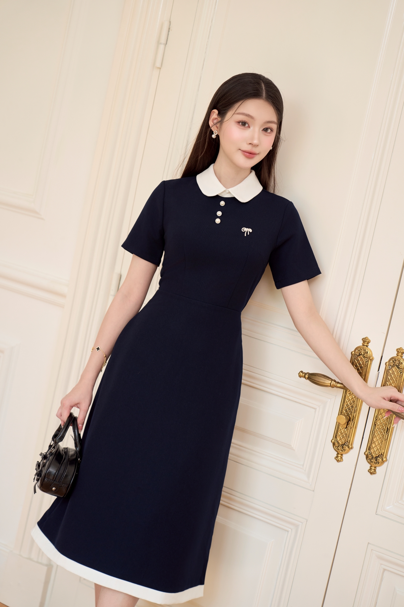 Mô tả Váy nữ dáng dài cổ sen ngắn tay phối viền trắng đính cúc ngọc và nơ đá trang trí YAME YV620 - 1