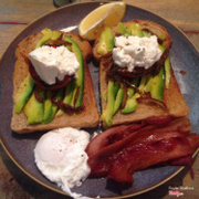 Avocado, ricotto, roasted tomato on toast with a side of a poached egg and bacon