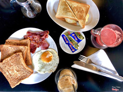 French toast với bacon và trứng ốp la. Sandwich kẹp trứng, sausage. Nước ép dưa hấu và cà phê sữa đá. 