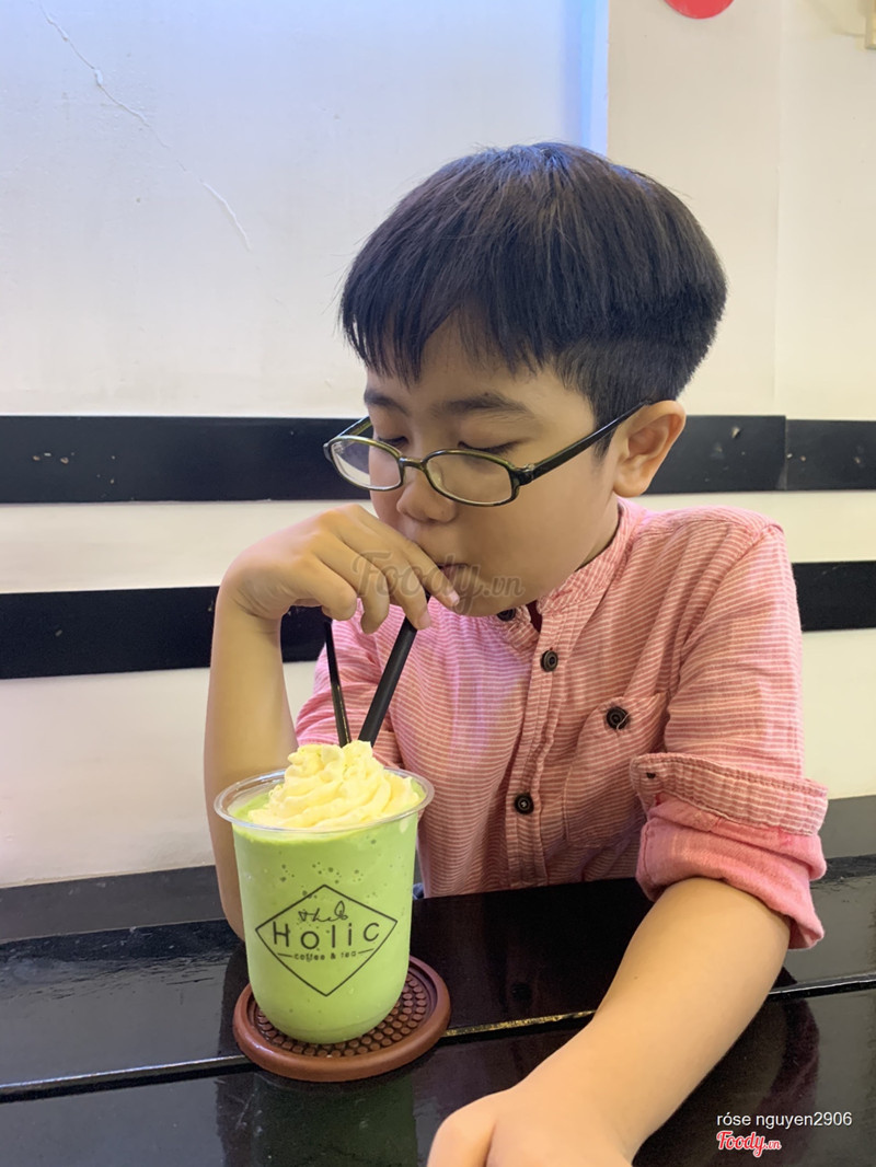 Bé con uống matcha đá xây, có vẻ thích thú 
