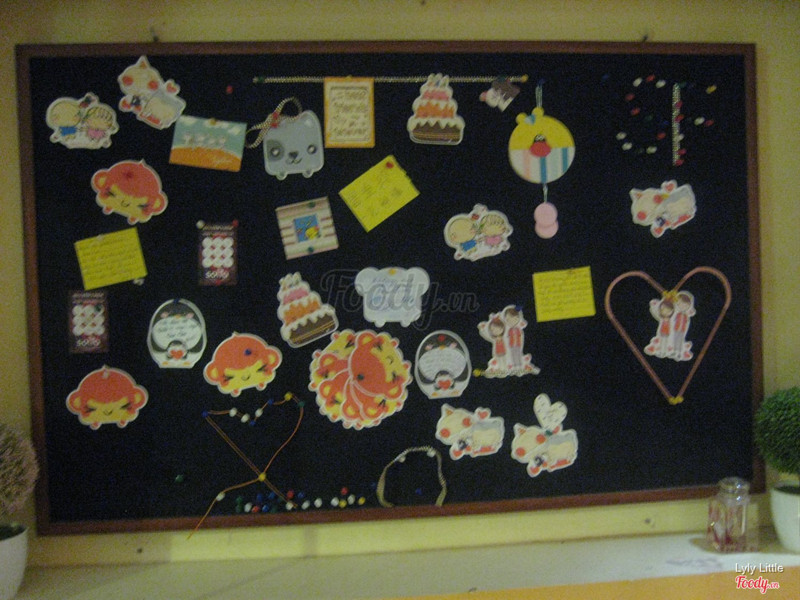 Quán có 1 cốc để các tấm thiệp nhỏ cho khách đến viết vào r pin lên bảng này.